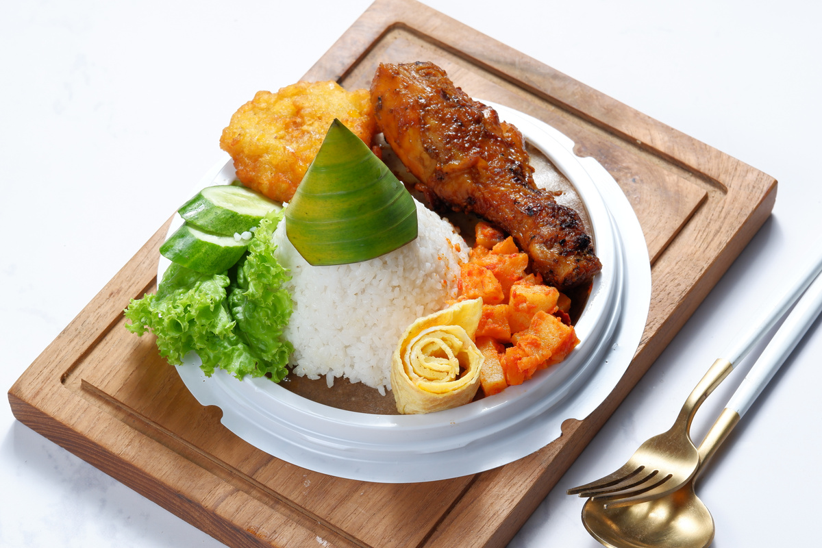 tumpeng mini or  A cone-shaped rice dish with side dishes of vegetables and chicken